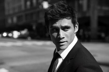 Black and white HD desktop wallpaper featuring a stylish man in a suit looking over his shoulder on a city street.