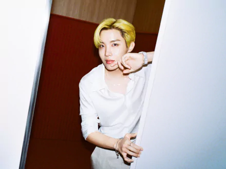 HD PC desktop wallpaper of a K-pop singer with blond hair in a white shirt, leaning from a doorway; minimalist music-themed background and crisp portrait-style composition.