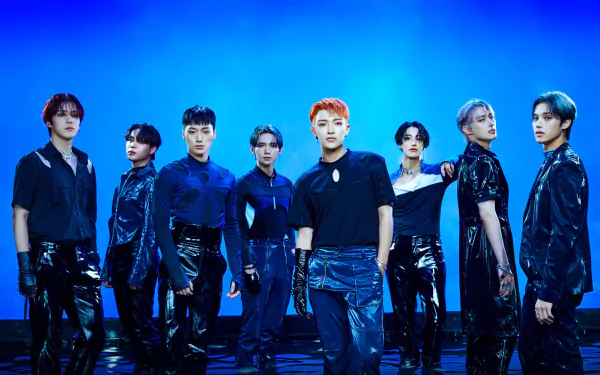 High-definition wallpaper featuring ATEEZ, showcasing all eight members in stylish black outfits against a vibrant blue background, capturing their dynamic energy and charisma.