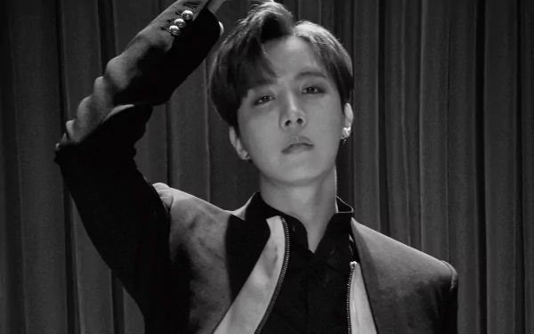 Black and white HD wallpaper of J-Hope from BTS, captured in a stylish pose, reflecting the dynamic energy of K-pop music and the artist's charisma.