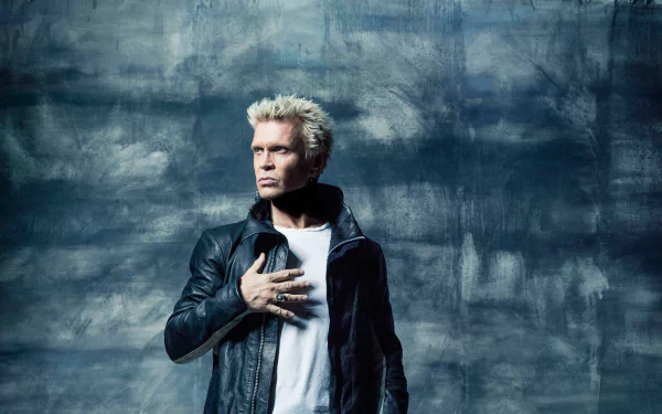 Billy Idol poses confidently against a textured blue background, showcasing his iconic style. This HD wallpaper captures the essence of music and rock culture seamlessly.