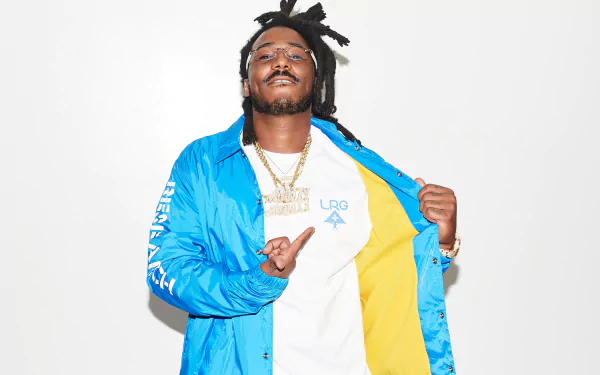 HD desktop wallpaper featuring a smiling person in a blue and yellow jacket against a white background, tagged with Mozzy.