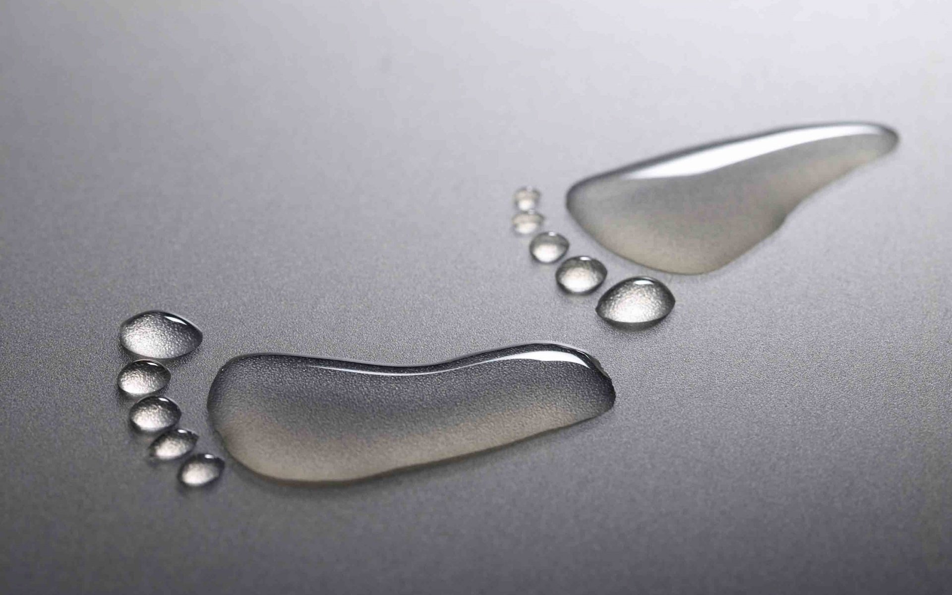 Close-up of abstract, artistic water droplets on a smooth surface, creating a visually striking HD desktop wallpaper and background.