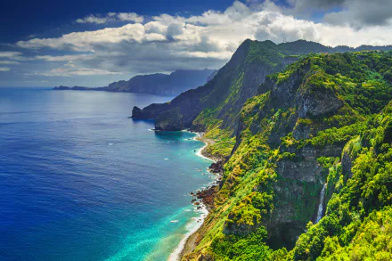 4K Ultra HD desktop wallpaper featuring Portugal's dramatic coastline with lush green mountains meeting the deep blue ocean under a partly cloudy sky.