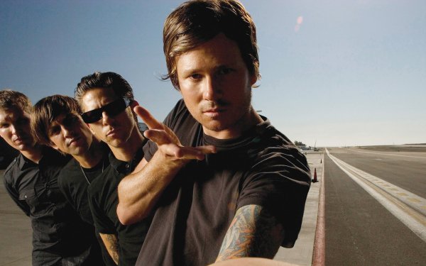 HD desktop wallpaper featuring a group of musicians posing on a deserted road under a clear sky, ideal for fans of alternative rock music and Angel and Airwaves supporters.