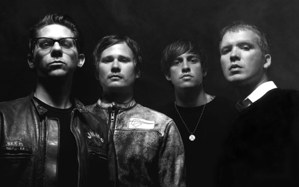 Black and white HD desktop wallpaper featuring the band members of Angels and Airwaves posing against a dark background, ideal for rock music fans' computer screens.
