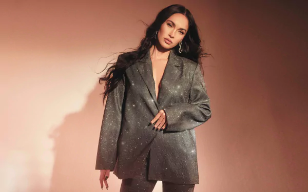 4K Ultra HD PC desktop wallpaper of a female celebrity in an oversized charcoal blazer, long dark hair, posing against a warm pink backdrop with soft, dramatic shadows.