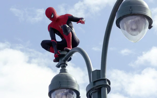 Spider-Man in his red and black suit perches atop street lamps against a cloudy sky in a 4K Ultra HD wallpaper from the movie Spider-Man: No Way Home.