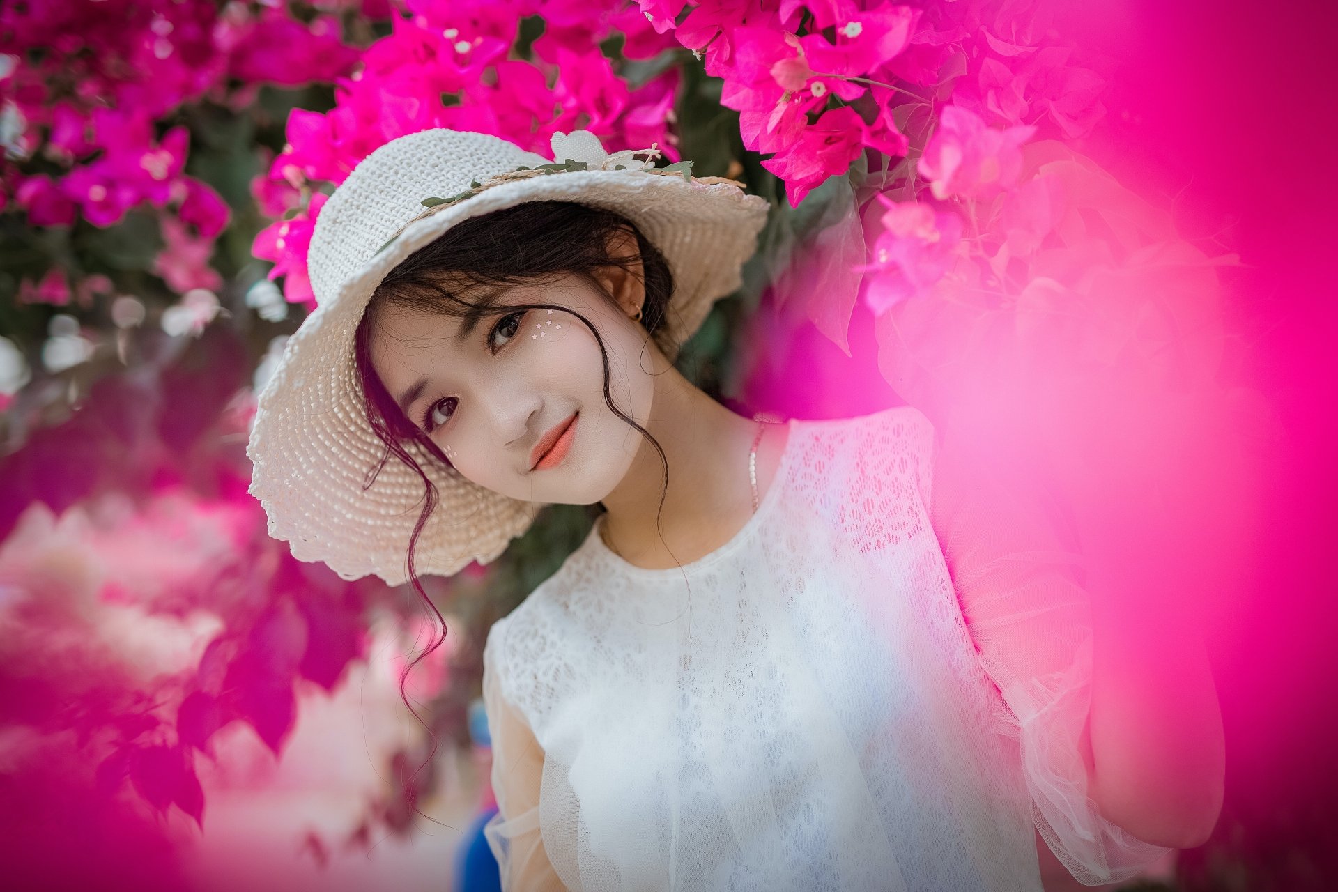 A young Asian woman wearing a white hat and dress poses among vibrant pink flowers in a high-resolution 4K Ultra HD desktop wallpaper.