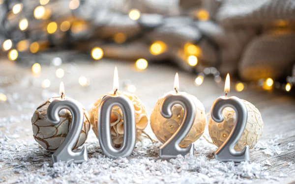 5K Ultra HD PC desktop wallpaper background: lit candle numerals spelling New Year 2022 amid holiday ornaments, warm bokeh lights, and a snowy surface.