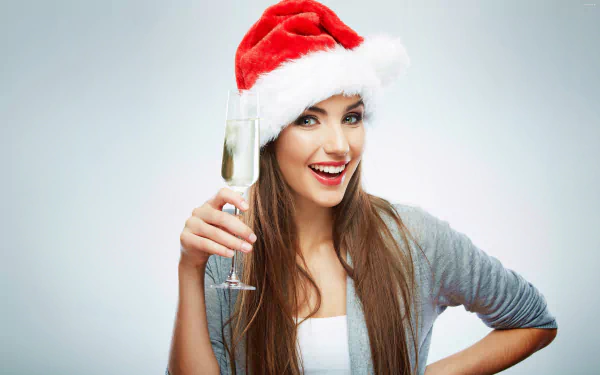 A smiling woman wearing a Santa hat holds a champagne glass, captured in vibrant detail for a 4K Ultra HD PC desktop wallpaper and background.