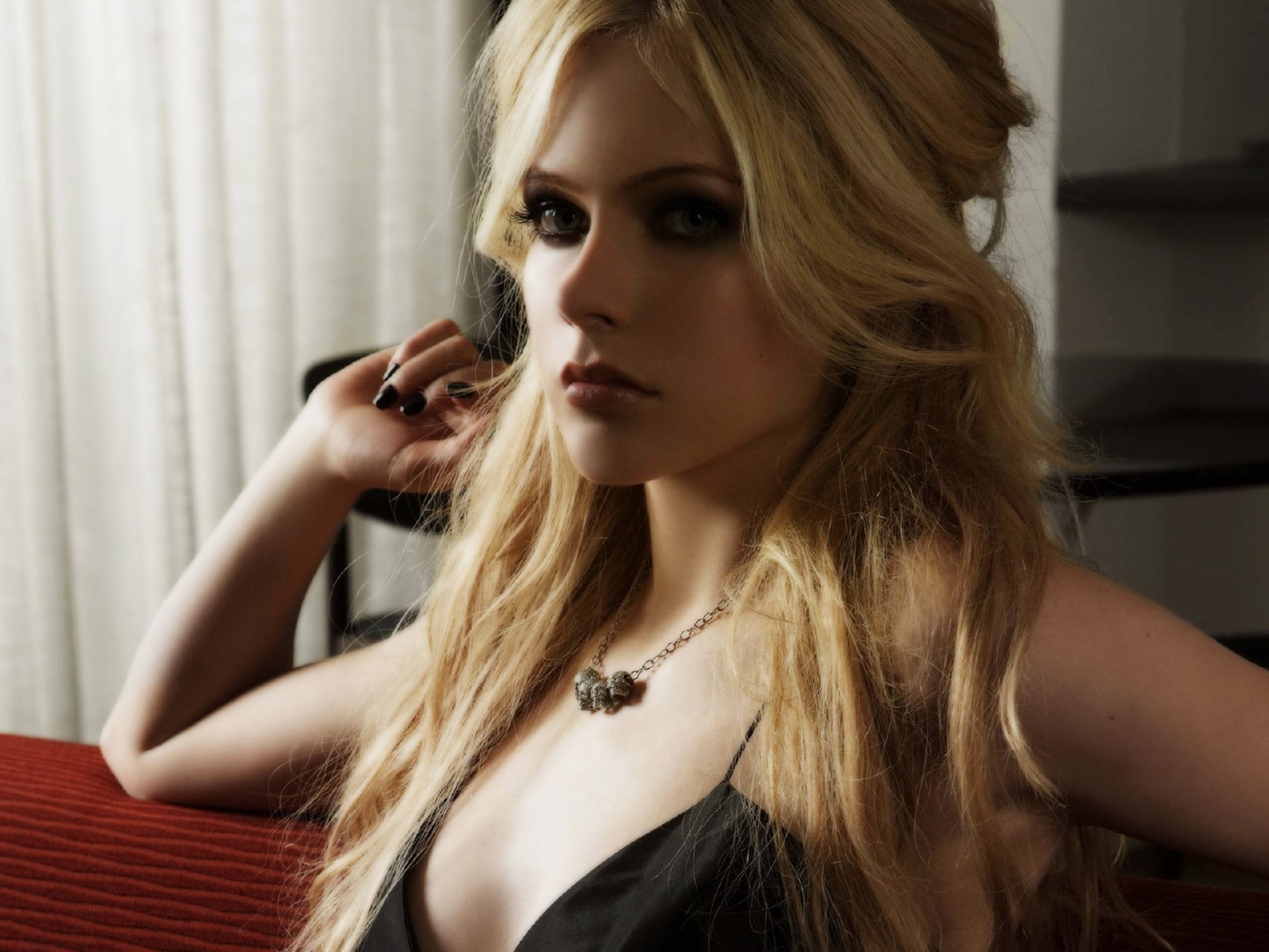 HD PC desktop wallpaper featuring Avril Lavigne in a close-up, moody portrait with soft lighting, highlighting her music star persona.