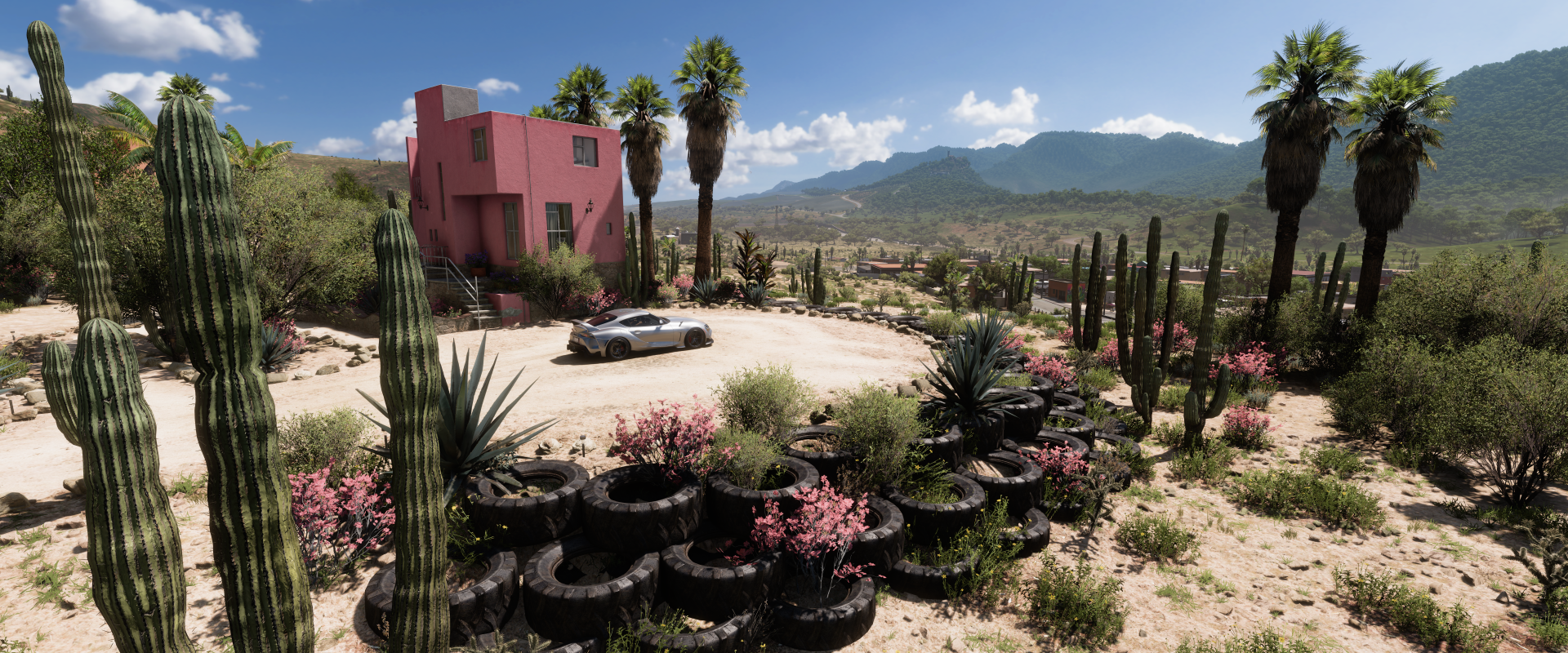 4K Ultra HD Forza Horizon 5 PC wallpaper featuring a desert landscape with cacti, a pink building, and a sports car under a clear blue sky.