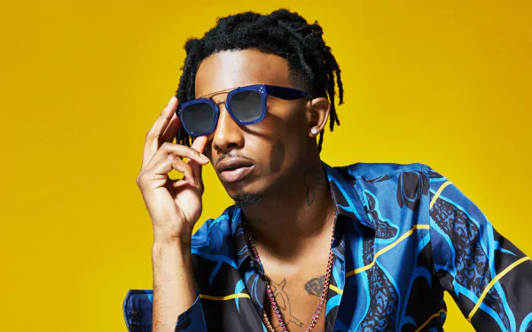 A stylish wallpaper featuring Playboi Carti, showcasing his cool demeanor against a vibrant yellow background, highlighting his unique fashion sense and personality.