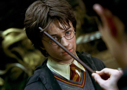 HD desktop wallpaper of Daniel Radcliffe as Harry Potter from the movie Harry Potter and the Chamber of Secrets, focusing on a close-up scene with his wand.