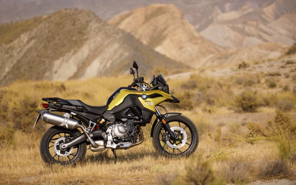 A BMW F750GS motorcycle parked in a desert landscape, featured as a 4K Ultra HD PC desktop wallpaper and background.