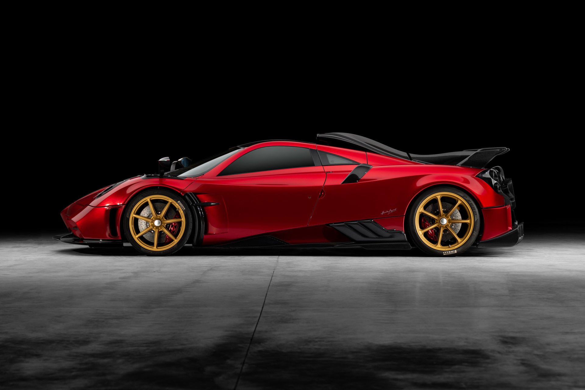 Sleek red Pagani Imola supercar with gold wheels showcased in an 8K Ultra HD PC desktop wallpaper against a dark background.