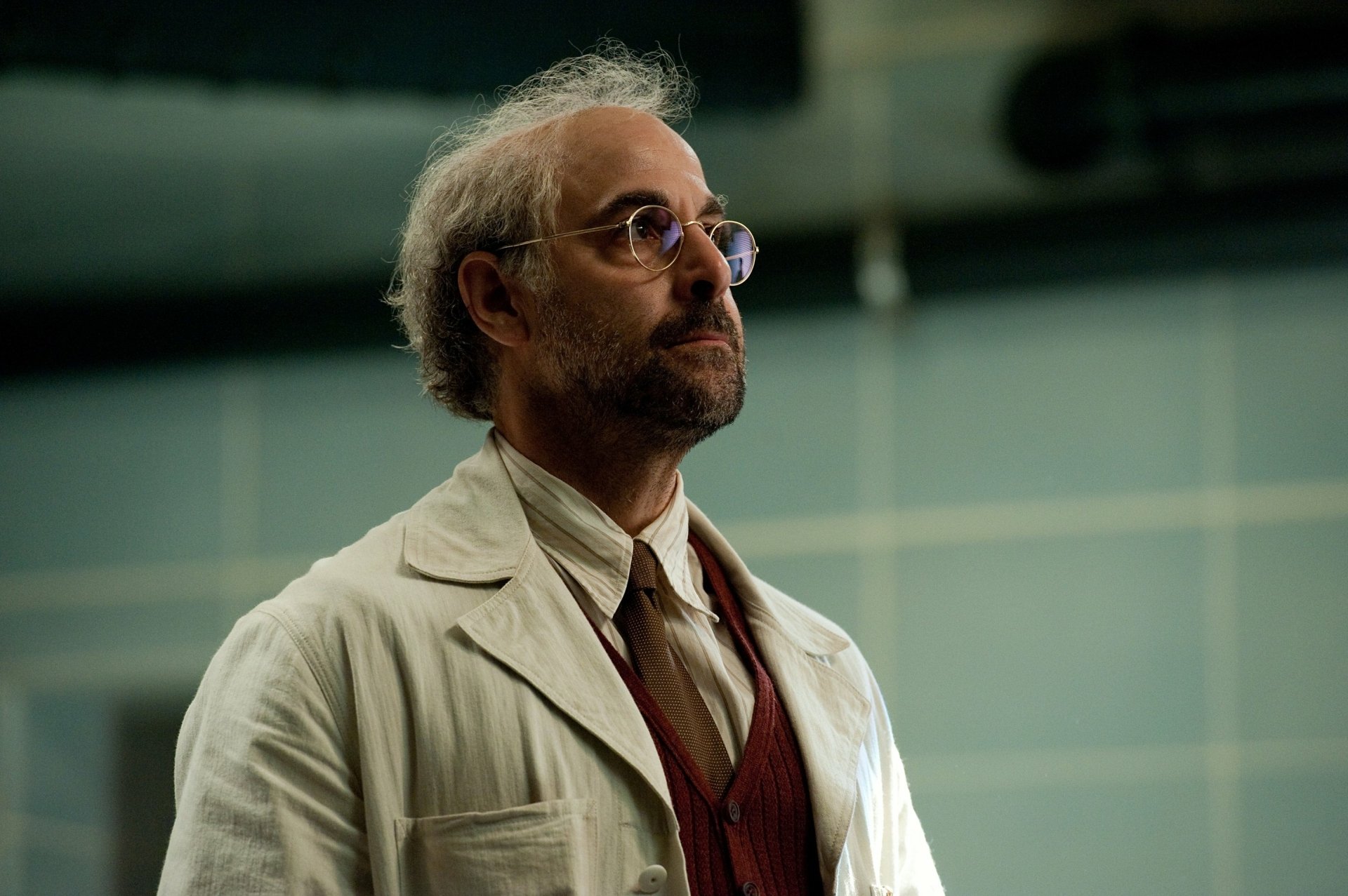 HD desktop wallpaper featuring Stanley Tucci in character from the movie Captain America: The First Avenger, wearing glasses and a white coat.