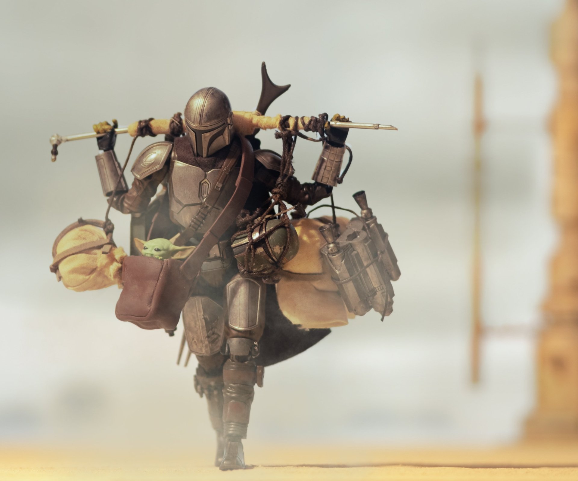 HD PC desktop wallpaper featuring The Mandalorian character from the TV show The Mandalorian, carrying gear with Baby Yoda strapped on his back.