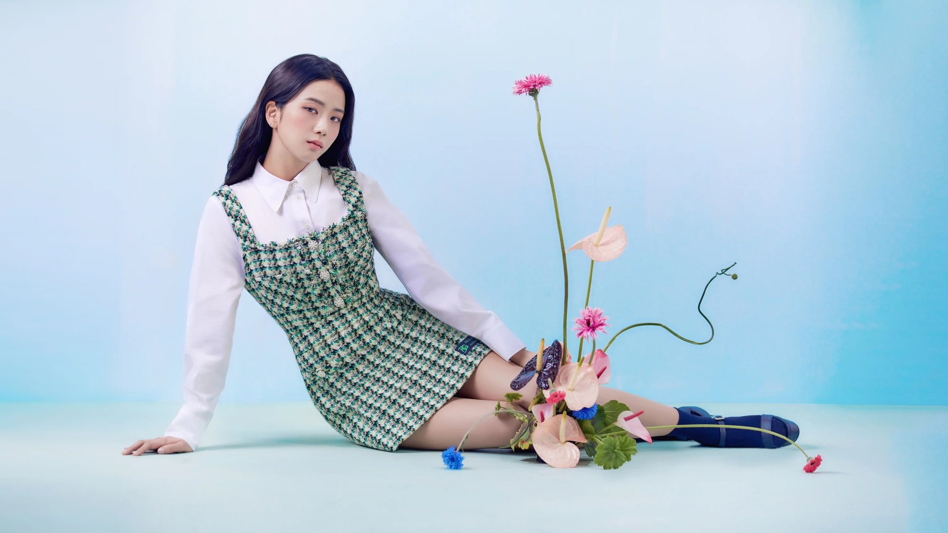 HD desktop wallpaper featuring Jisoo, singer of BlackPink, posed gracefully against a light blue background with colorful flowers.