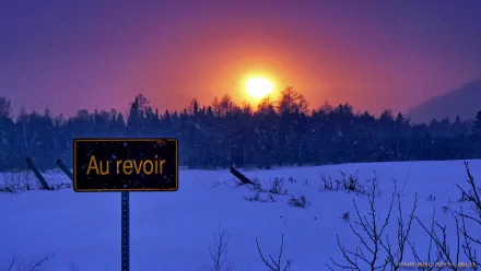 A stunning sunset illuminates a snowy landscape, with a black sign reading Au revoir in the foreground. This HD wallpaper captures the beauty of nature.