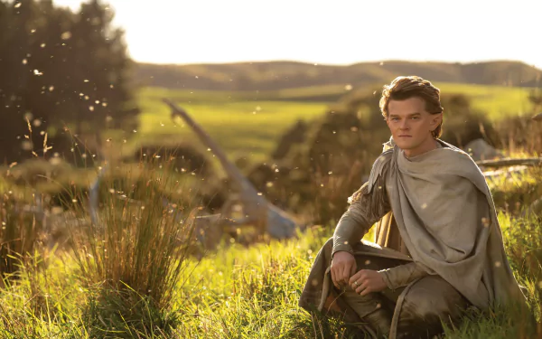 Robert Aramayo as Elrond from The Lord of the Rings: The Rings of Power, captured in a 4K Ultra HD TV show wallpaper with a serene, sunlit natural backdrop.