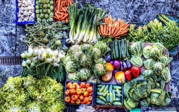A vibrant market filled with a variety of fresh vegetables, including carrots, lettuce, and peppers, creating a colorful display for an HD desktop wallpaper and background.