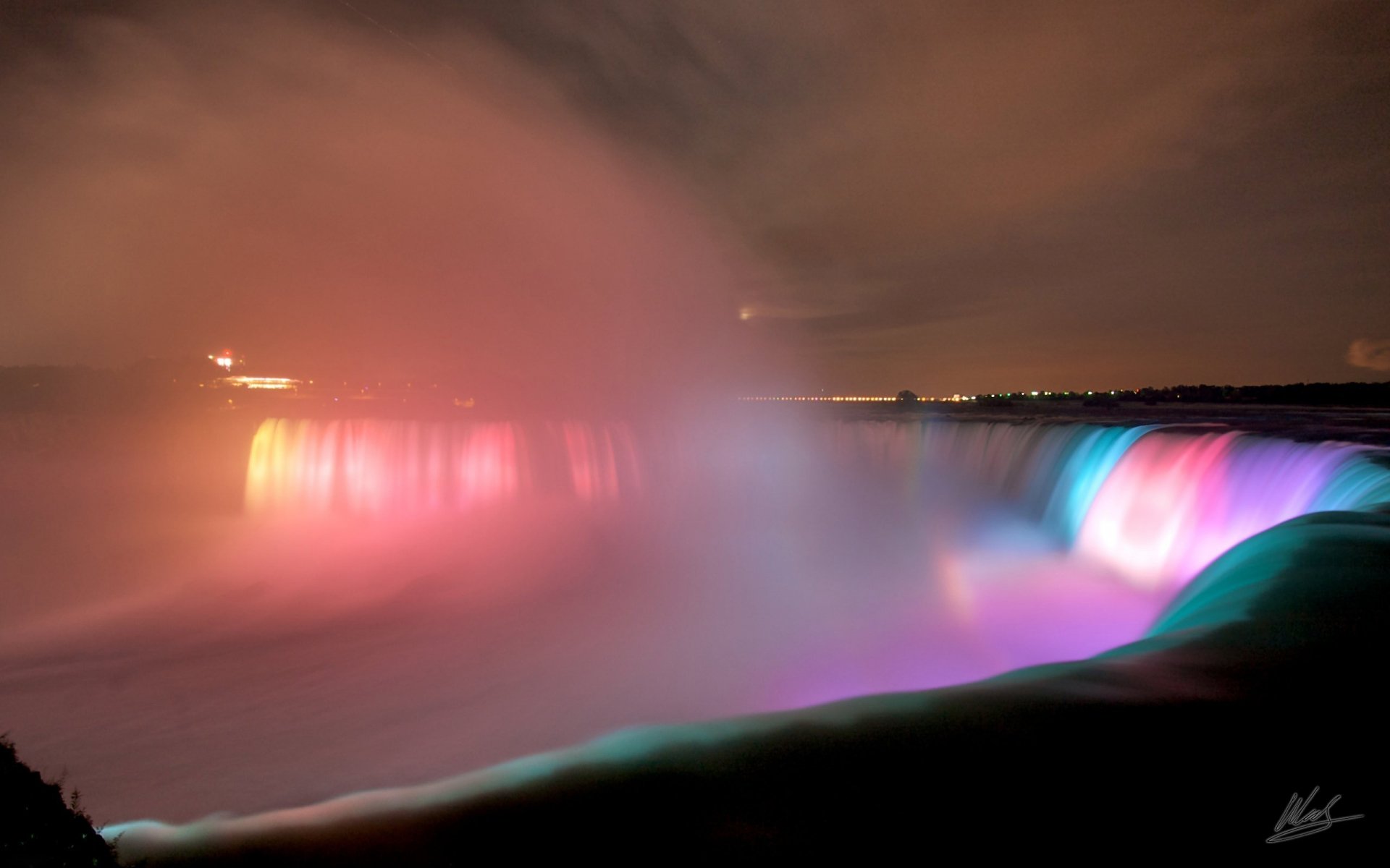 Night view of Niagara Falls illuminated with colorful lights, captured as a stunning HD PC desktop wallpaper showcasing the natural beauty of the waterfall.