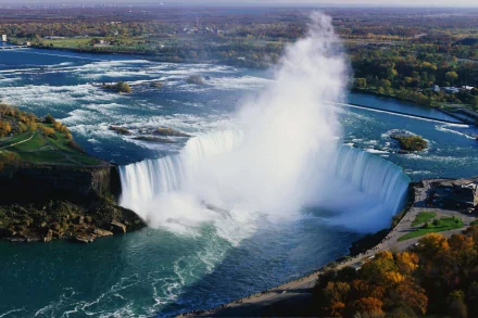 A stunning HD desktop wallpaper featuring the majestic Niagara Falls surrounded by lush greenery and calm waters, capturing the beauty of nature.