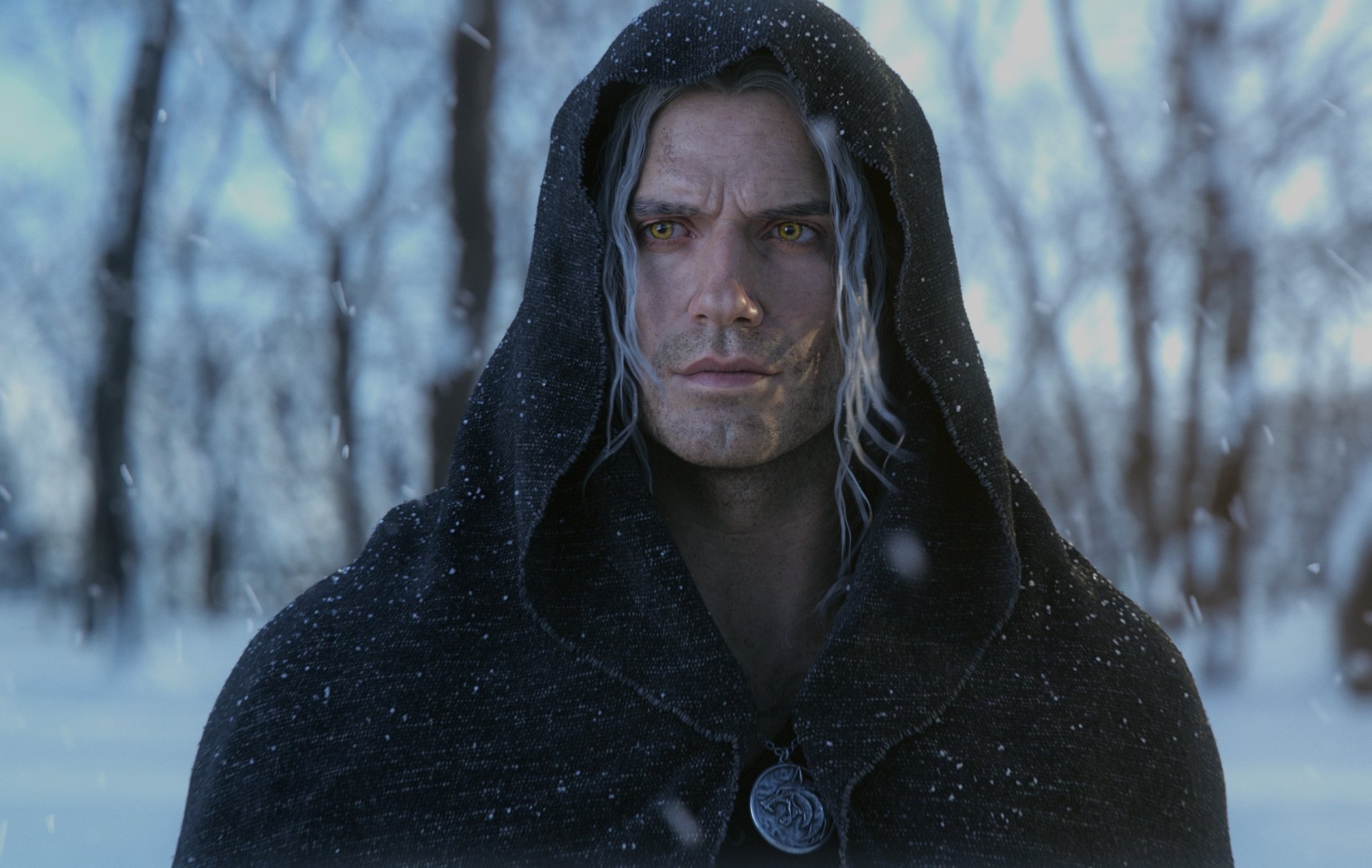 HD PC desktop wallpaper featuring Henry Cavill as Geralt of Rivia from The Witcher TV show, set against a snowy, blurred forest background.