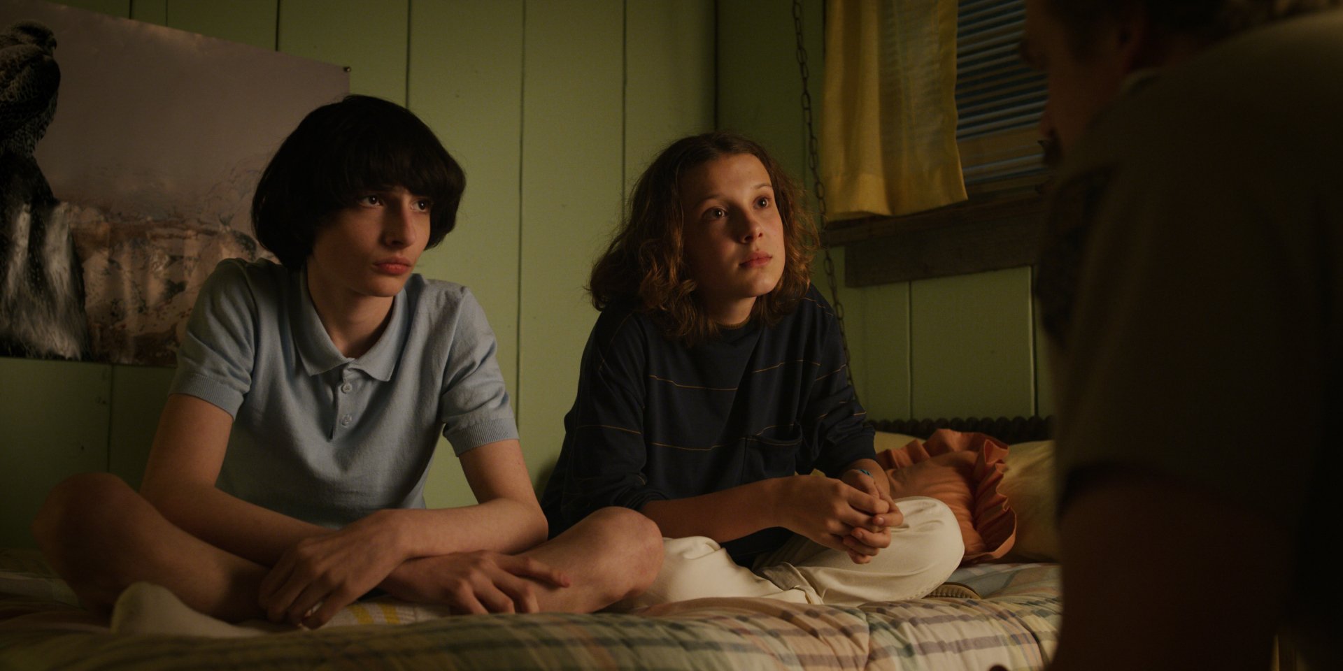 Millie Bobby Brown as Eleven and Finn Wolfhard as Mike Wheeler from Stranger Things in a 4K Ultra HD TV show wallpaper, capturing a tense moment indoors.