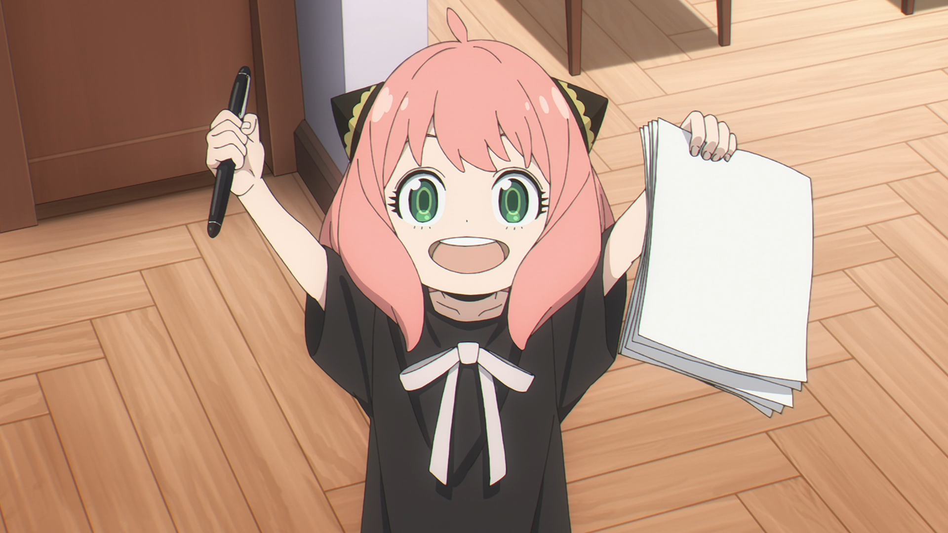HD PC desktop wallpaper featuring Anya Forger from the anime Spy x Family, smiling enthusiastically while holding a stack of papers and a pen.