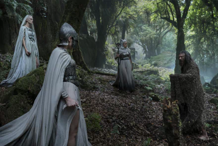 HD desktop wallpaper from The Lord of the Rings: The Rings of Power TV show, showing four characters in medieval attire in a misty, forested setting.