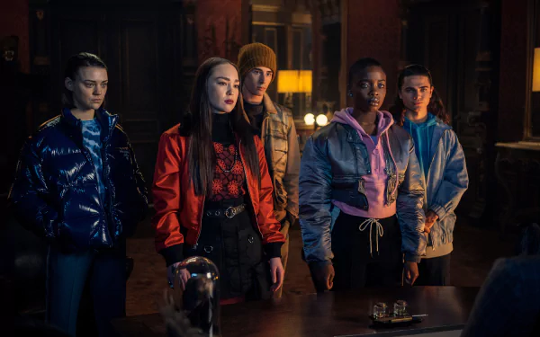 HD PC desktop wallpaper of five characters from the TV show Wednesday in a dim, gothic room, wearing jackets and standing alert.