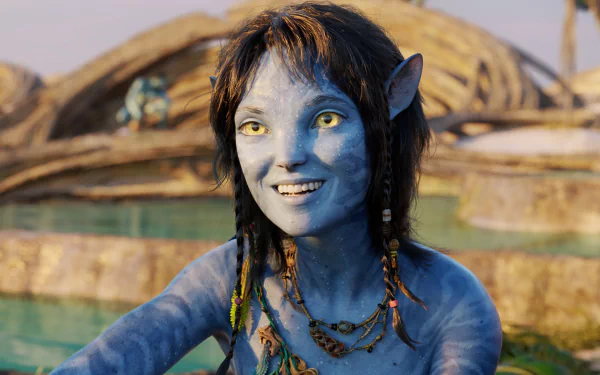 HD PC desktop wallpaper featuring a character from the movie Avatar: The Way of Water, showcasing a blue-skinned, yellow-eyed Na'vi with braided hair and a joyful expression.