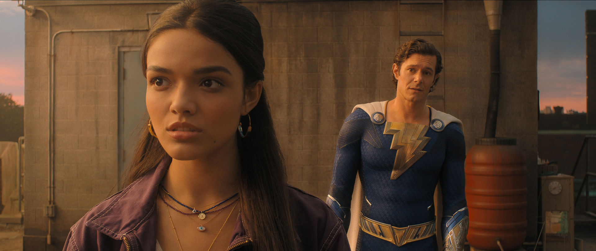 Young woman in the foreground with a lightning-emblazoned costumed hero behind her, 2K Quad HD desktop wallpaper from the movie Shazam! Fury of the Gods.