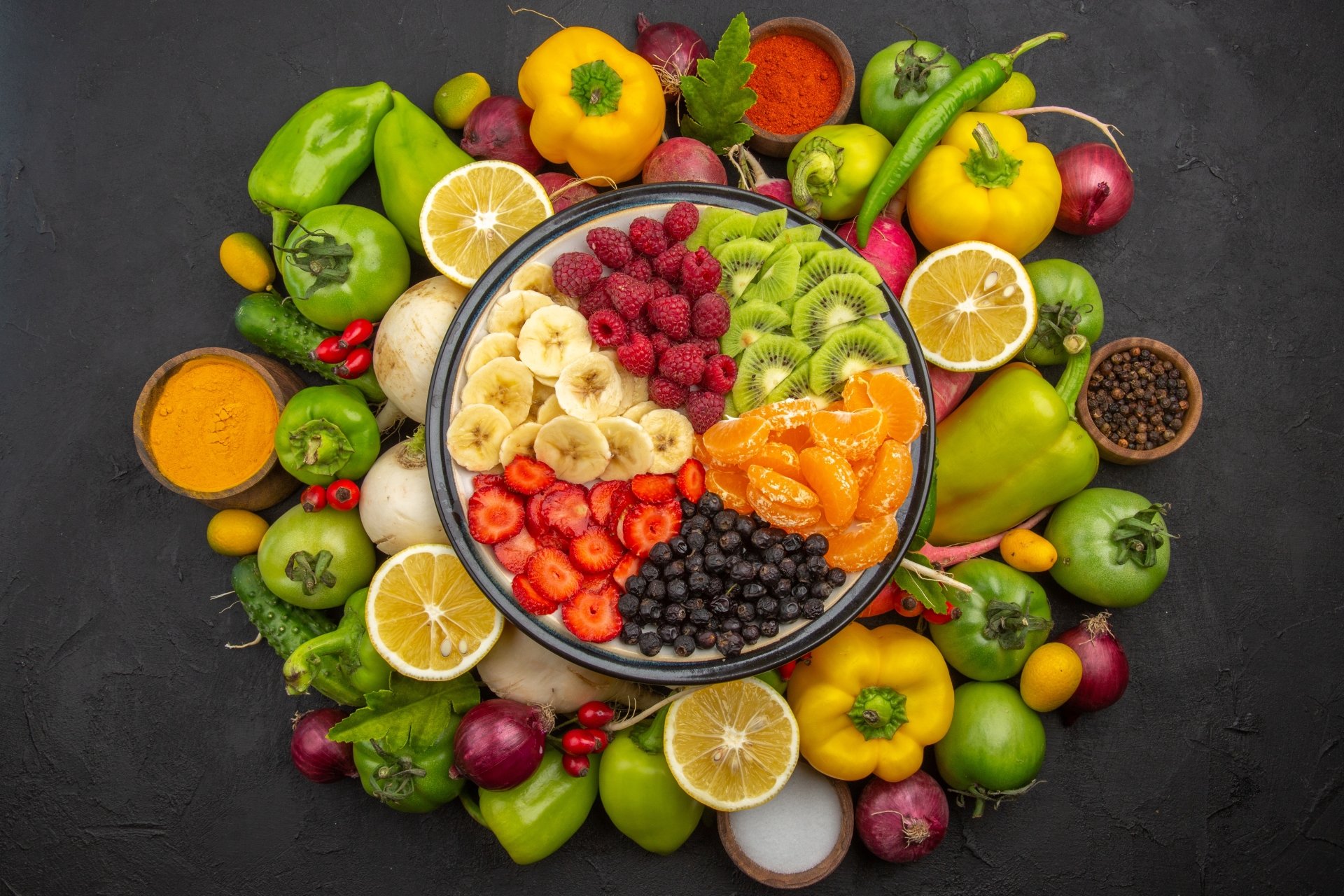 A vibrant 4K Ultra HD PC desktop wallpaper featuring a colorful assortment of fresh fruits and vegetables arranged around a divided bowl of sliced fruit.