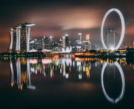 Nighttime cityscape of Singapore featuring the Marina Bay Sands and Singapore Flyer with vibrant reflections on the water, captured in 4K Ultra HD resolution.