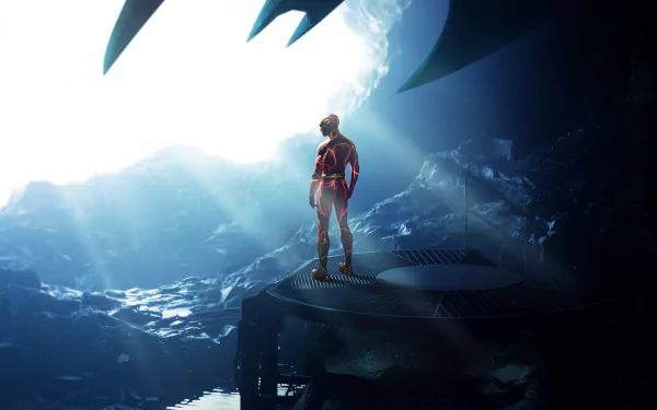 4K Ultra HD PC desktop wallpaper: The Flash (2023) in a scarlet suit stands on a rocky platform inside a glowing cavern, a giant bat-shaped silhouette looming overhead.