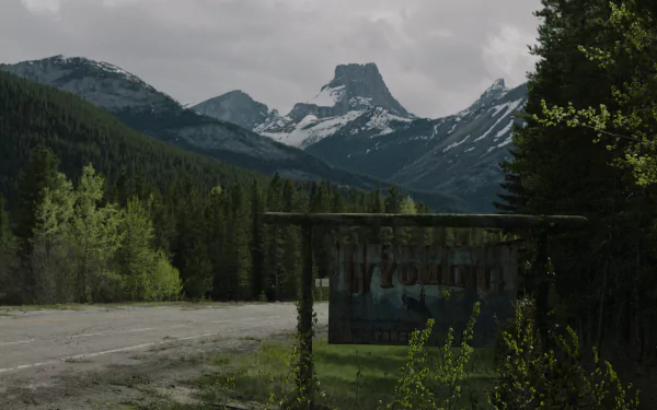 4K Ultra HD PC wallpaper: overgrown roadside, faded town sign and distant snow-capped peaks, moody post-apocalyptic scene from The Last of Us TV show.
