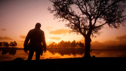 HD PC desktop wallpaper of Arthur Morgan from the video game Red Dead Redemption 2, silhouetted against a sunset by a tree near a calm lake.