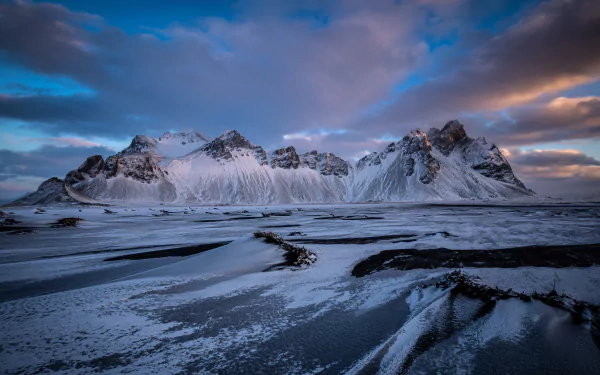 Snow-covered Vestrahorn mountains under a dramatic sky, captured in stunning 4K Ultra HD for a nature-themed PC desktop wallpaper.