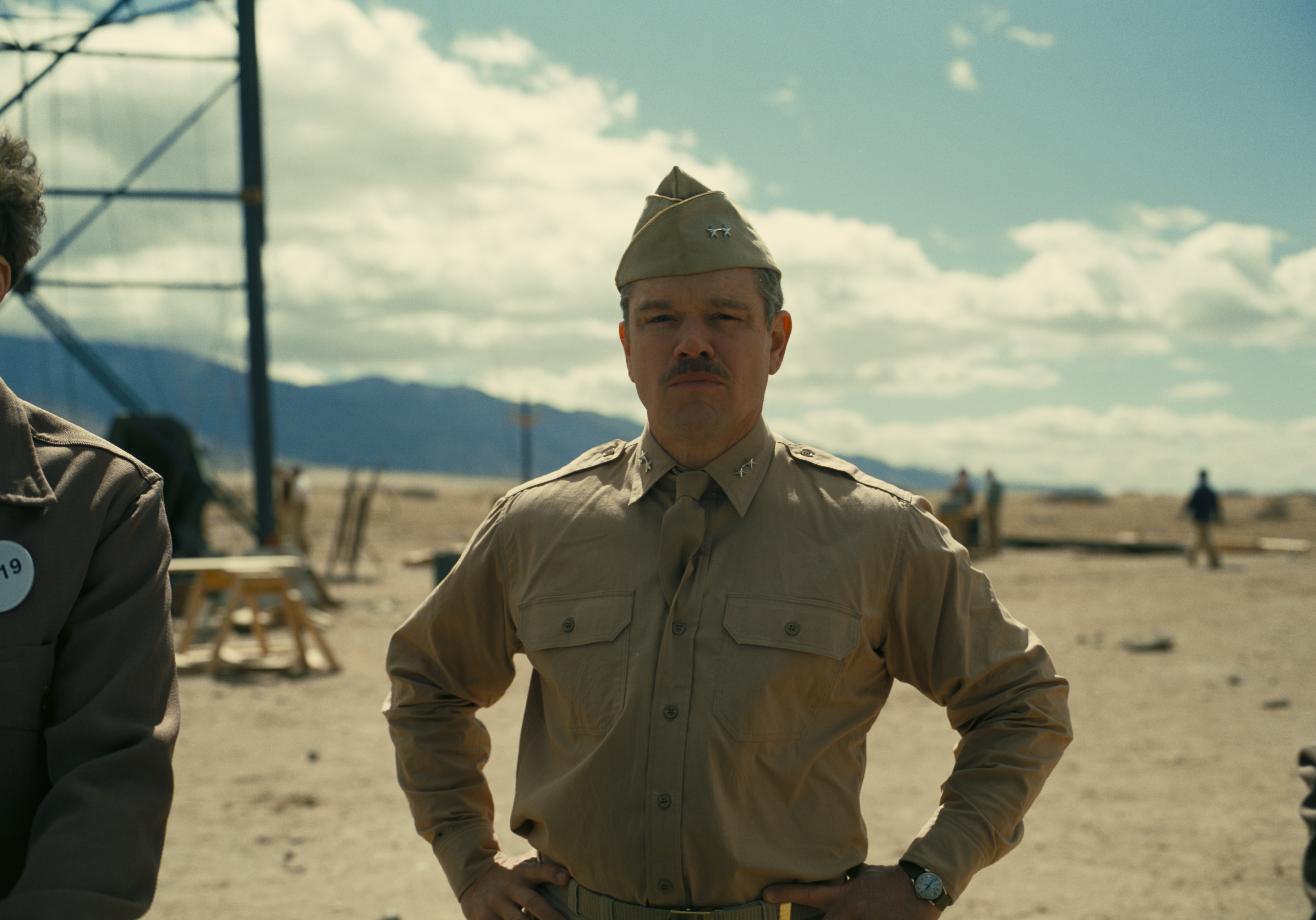 HD desktop wallpaper featuring a man in a vintage military uniform standing with confidence against a desert backdrop, reminiscent of a historical drama scene.