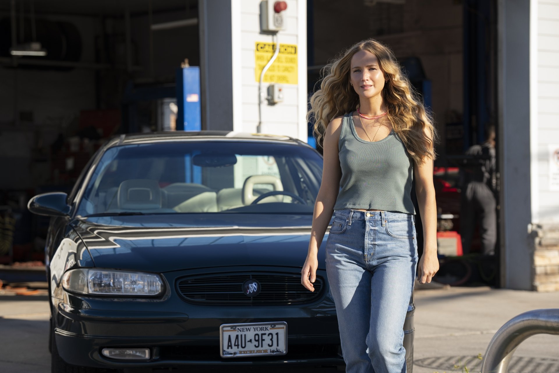 Woman smiling walking in front of a car with an open garage in the background, tagged with No Hard Feelings, HD desktop wallpaper and background.