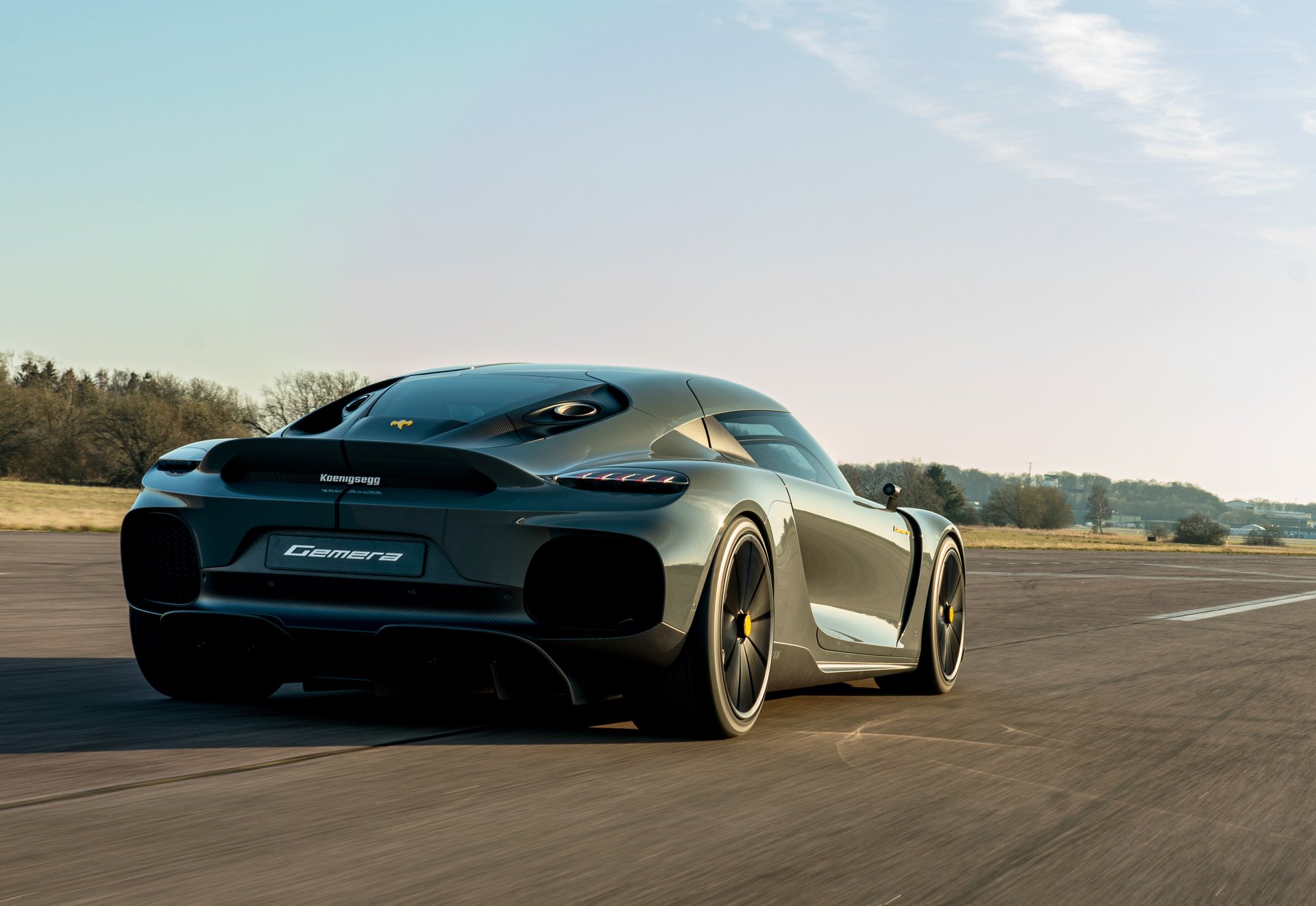 HD wallpaper of a Koenigsegg Gemera supercar on a runway, showcasing its sleek design and dynamic performance as a desktop background.