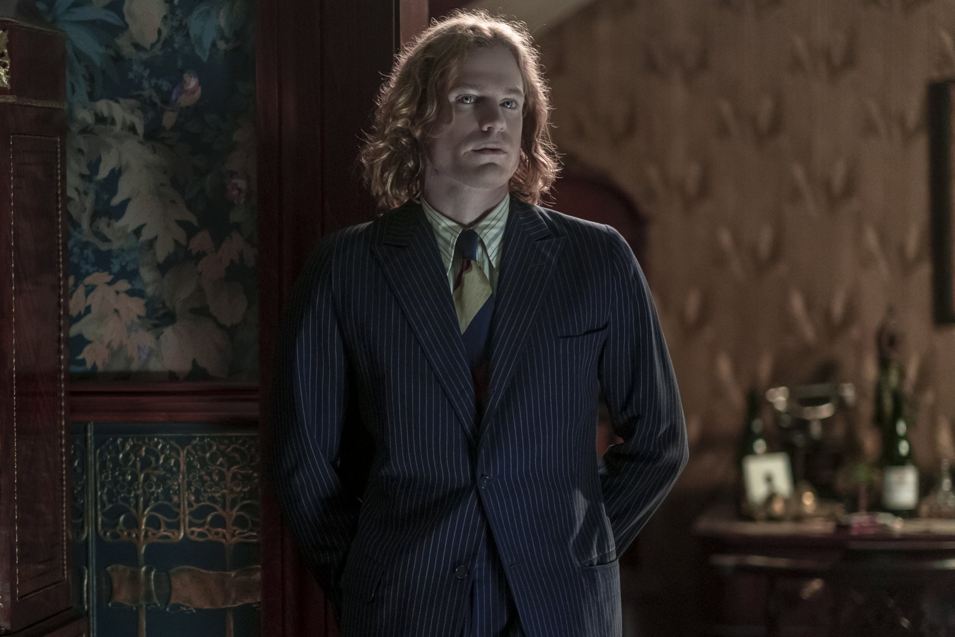 HD wallpaper featuring a scene from Interview with the Vampire, with a character in a pinstripe suit standing in a vintage room.