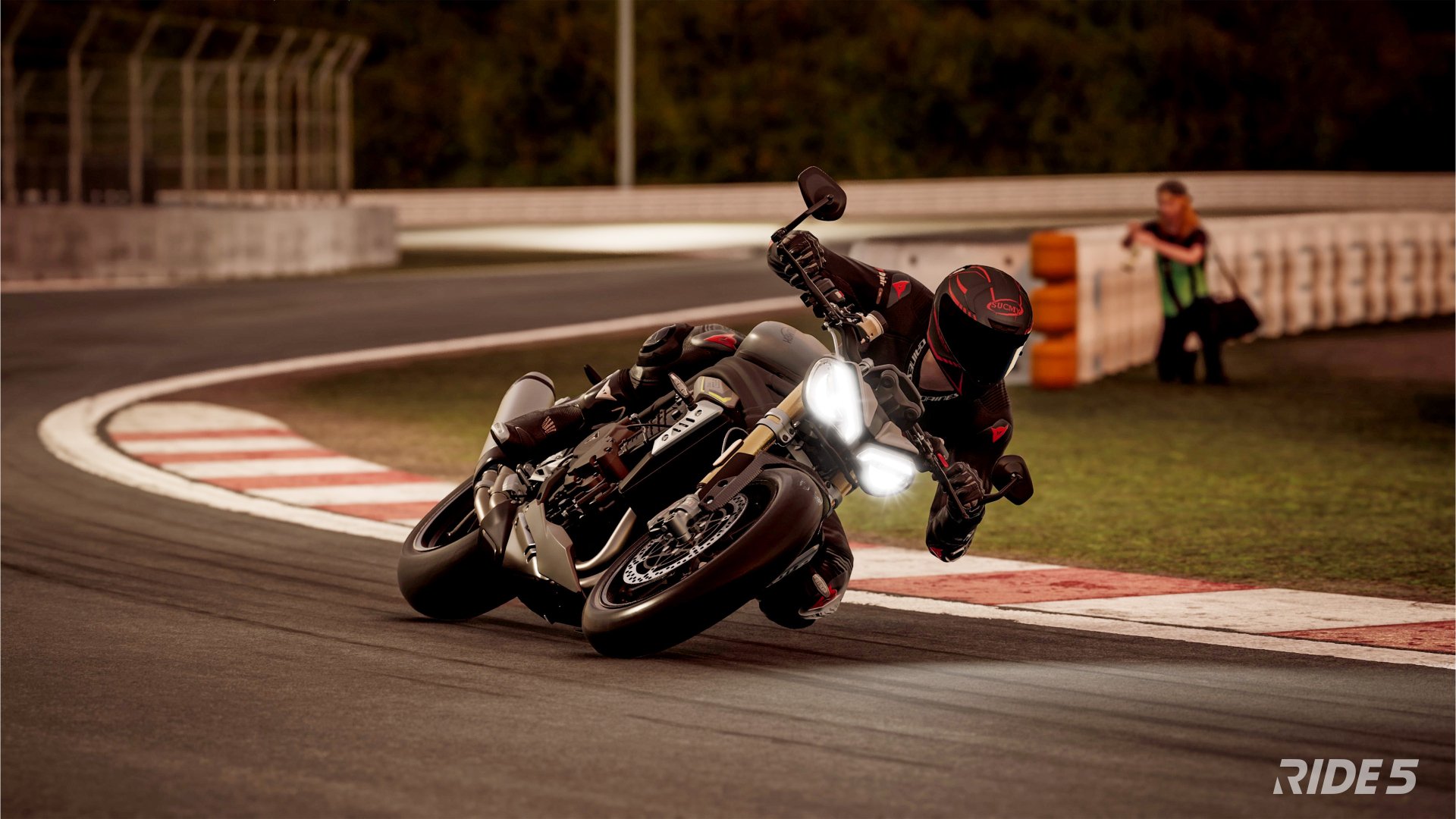 HD desktop wallpaper from the video game Ride 5 featuring a motorcyclist sharply cornering on a racetrack, demonstrating dynamic motion and detailed graphics.