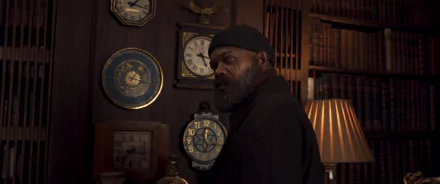 HD desktop wallpaper featuring a mysterious man in a beanie and coat inside a room with vintage clocks and bookshelves, tagged with Secret Invasion.