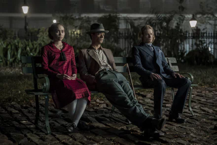 HD wallpaper featuring three actors sitting on a bench in a moody, dimly-lit setting, evocative of the series 'Interview with the Vampire'.