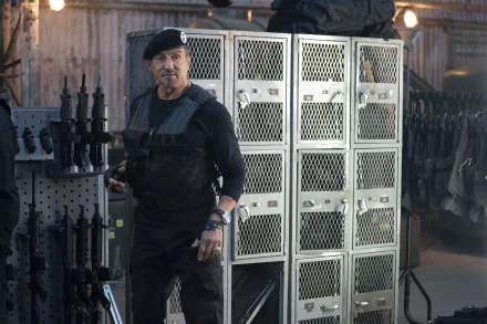 HD wallpaper featuring a character from Expendables, portrayed by an actor, standing confidently in front of a weapons rack.